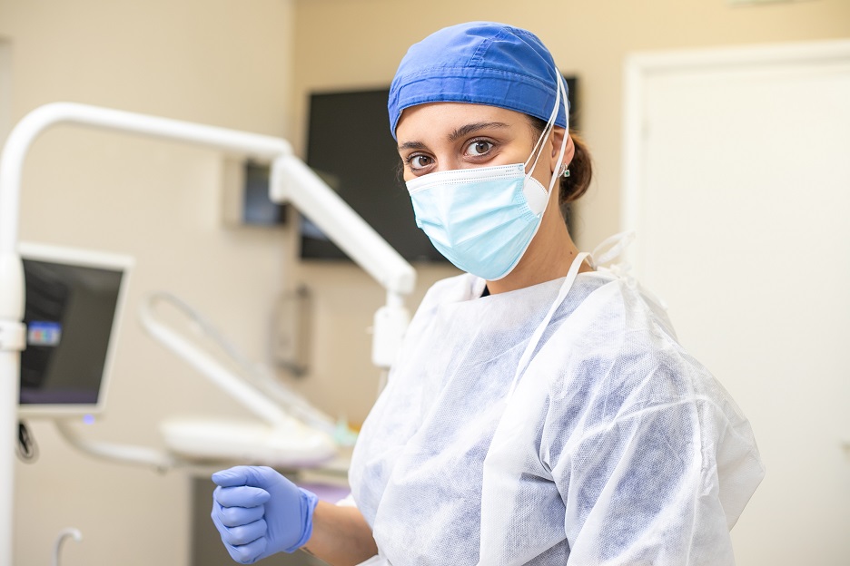 Assistente alla poltrona di un dentista sorridente