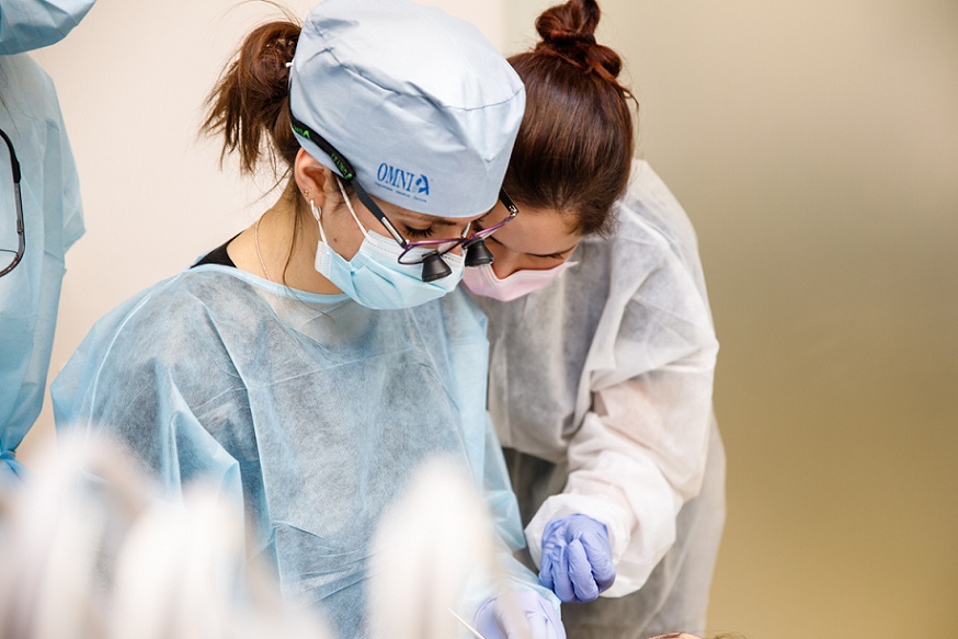 Odontoiatra e igienista che trattano insieme un paziente durante un’esercitazione pratica Periocampus