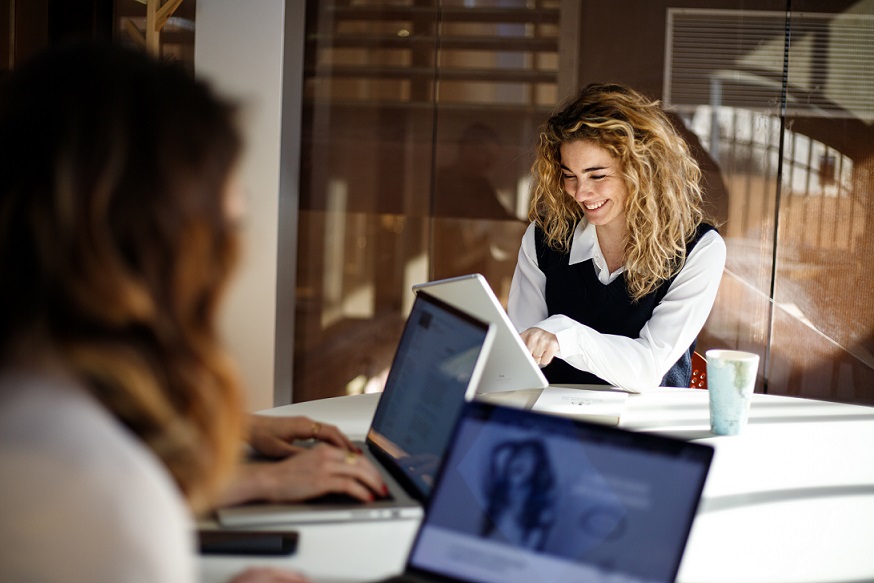 Ragazze felici che parlano e che guardano il tablet